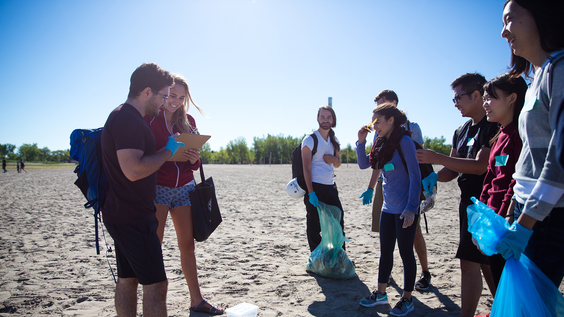 A group participating in a shoreline cleanup gathered on the beach