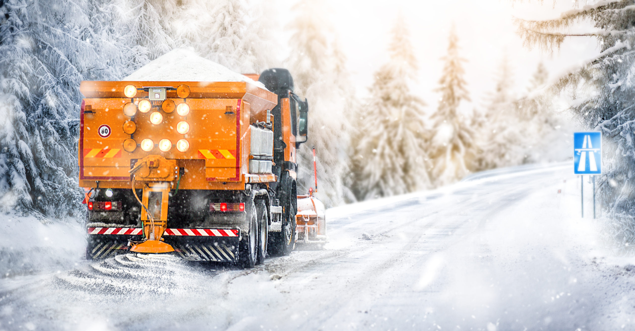 Road Salt truck drives down winter road