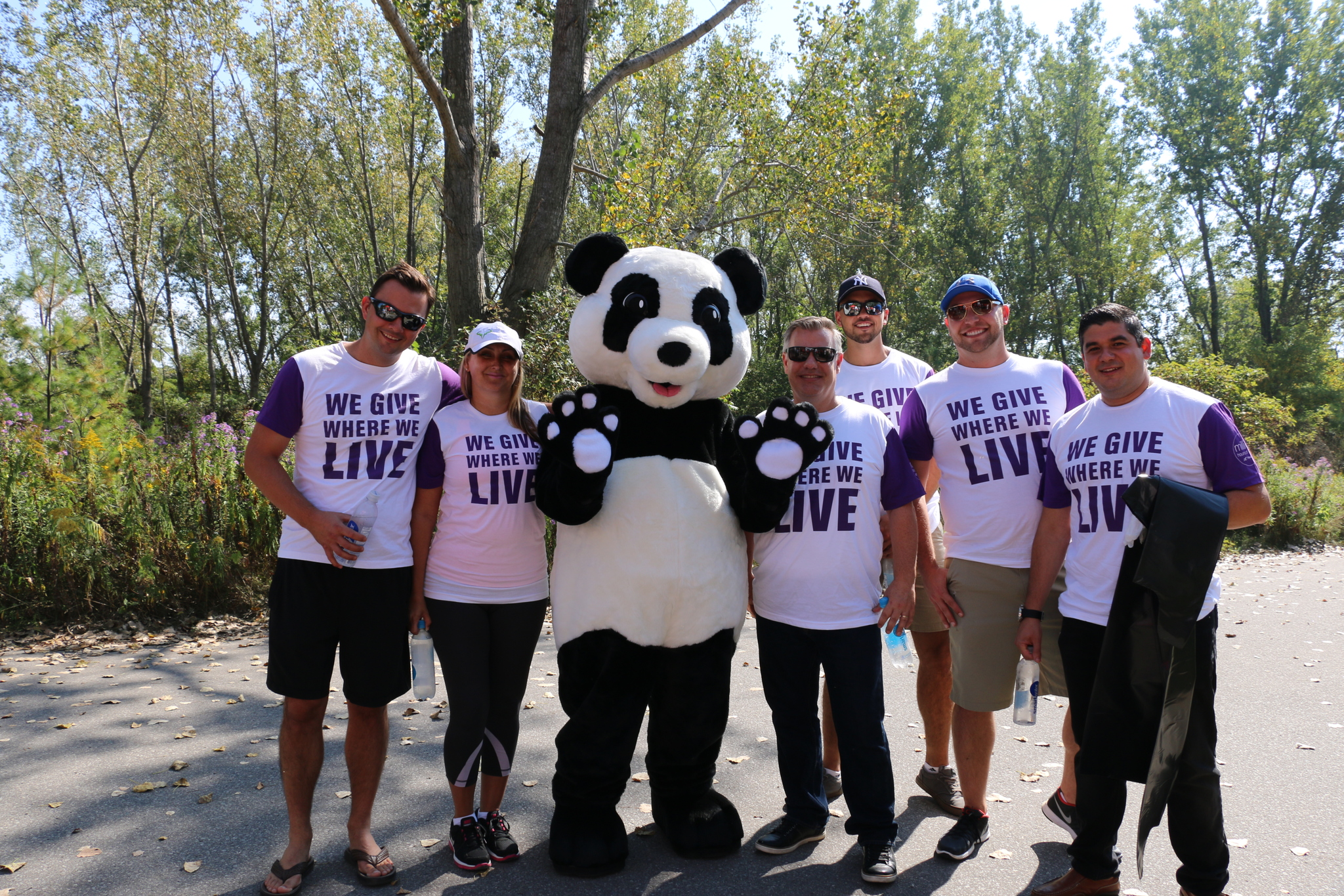 Telus employees posing with the WWF Panda mascot outdoors